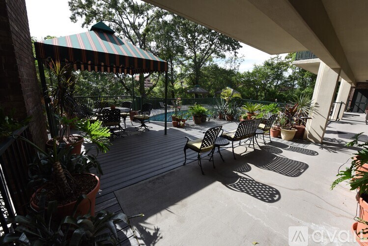A patio with a striped awning and a pool table.