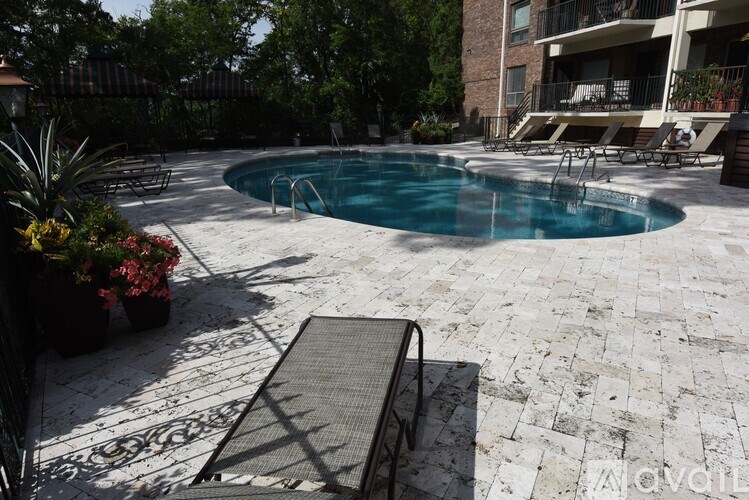 A pool surrounded by a patio and a building.