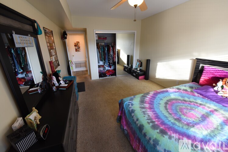 A bedroom with a bed, a wardrobe, and a vanity with a mirror.
