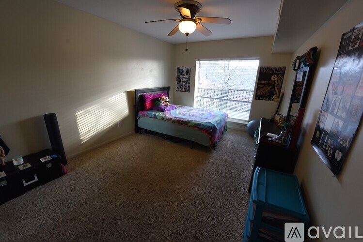 A bedroom with a bed, dresser, and a ceiling fan.