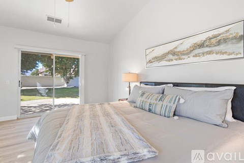 A bedroom with a large bed and a painting on the wall.