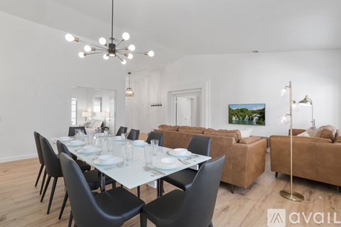 A dining room with a white table and black chairs.