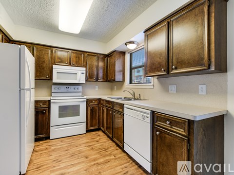 A kitchen with wooden cabinets and white appliances.