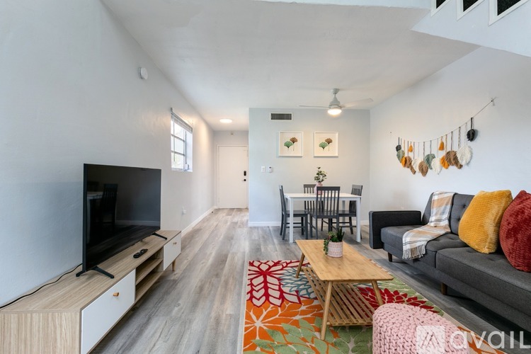A living room with a grey couch, a wooden coffee table, and a television on a cabinet.