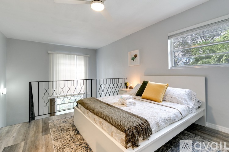 A bedroom with a large bed and a window with a view of trees outside.