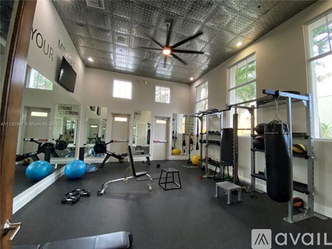 A gym with a variety of equipment including a punching bag.