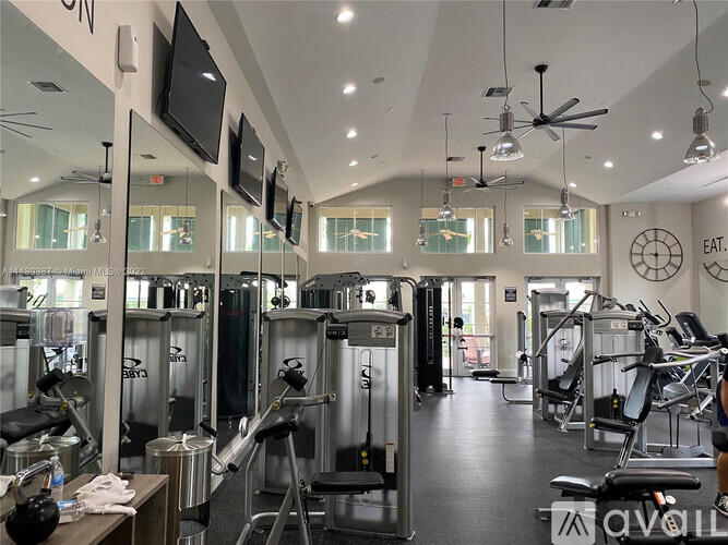 A gym with a variety of equipment including treadmills, weights, and exercise machines.
