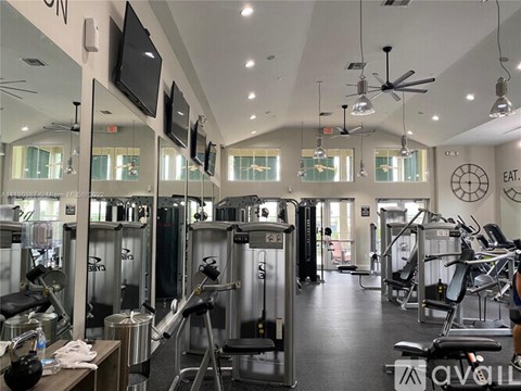 A gym with a variety of equipment including treadmills, weights, and exercise machines.