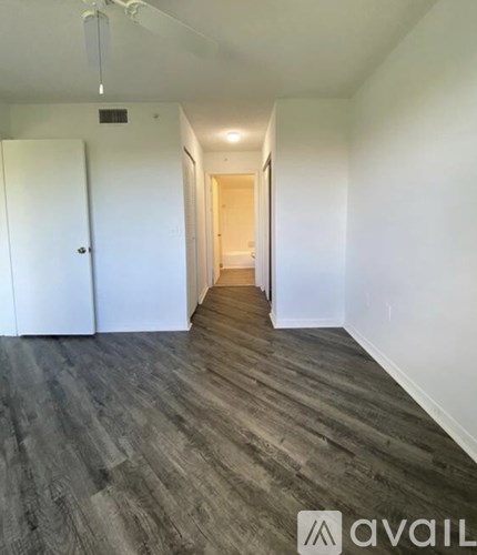 A long hallway with a white door on the left and a wooden door on the right.