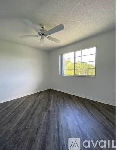 A room with a ceiling fan and a window.