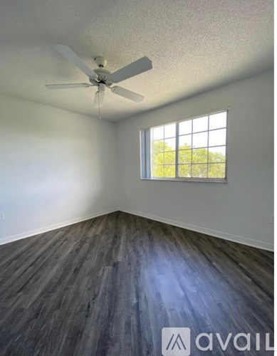 A room with a ceiling fan and a window.