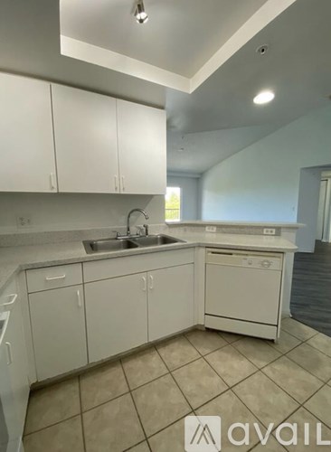 A kitchen with white cabinets and a tiled floor.