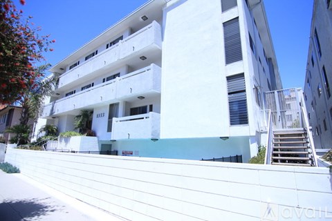 A white building with a balcony and stairs.