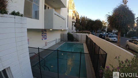 A pool surrounded by a black fence in a backyard.