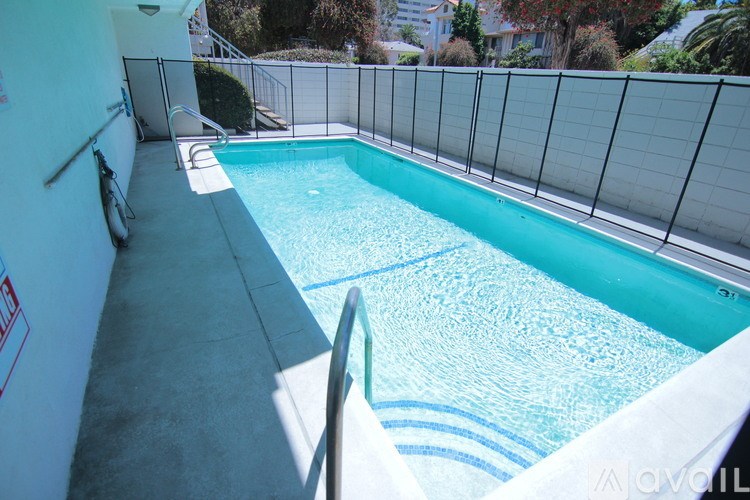A small pool with a white fence around it.