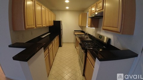 A kitchen with black countertops and wooden cabinets.