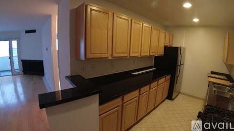 A kitchen with wooden cabinets and black countertops.