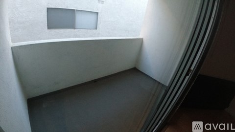 A white building with a window and a dark floor.