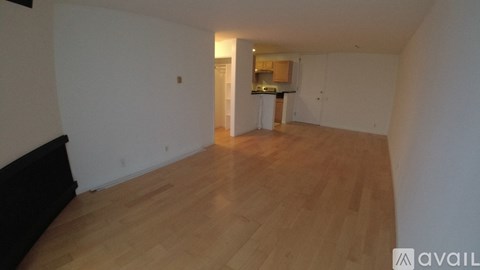 A room with wooden flooring and white walls.