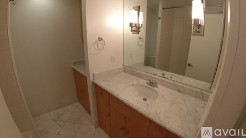 A bathroom with a marble countertop and a large mirror.