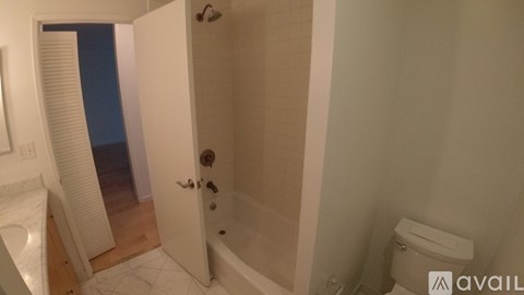 A bathroom with a toilet, tub, and shower.