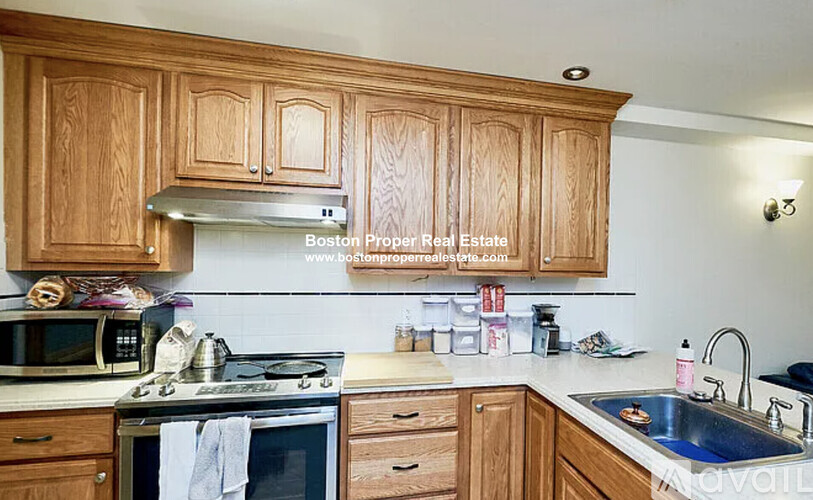 A kitchen with wooden cabinets and a stove top oven.