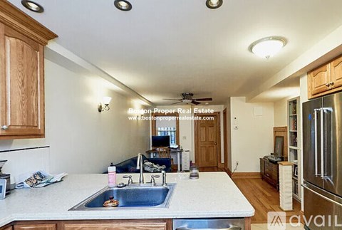 A kitchen with a sink and a refrigerator.
