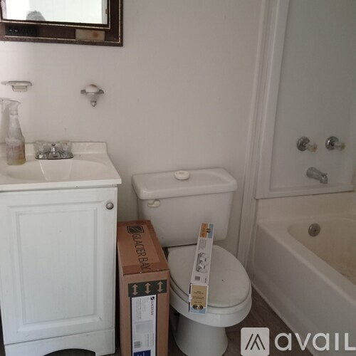 A white toilet with a white sink and a white bathtub in a bathroom.