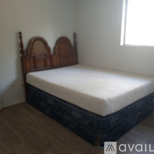 A bed with a wooden headboard and footboard sits in a room.
