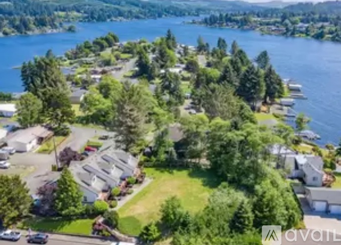 A bird's eye view of a residential area with houses, trees, and a body of water.