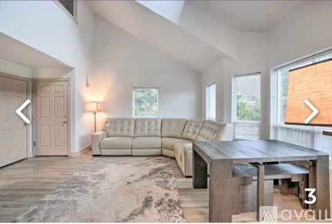 A spacious living room with a large sectional sofa and a wooden coffee table.