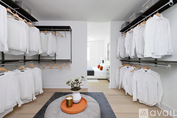 A room with white shirts hanging on racks.