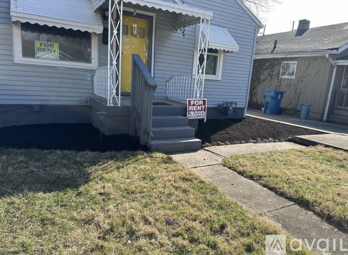 A house with a "For Rent" sign in front of it.