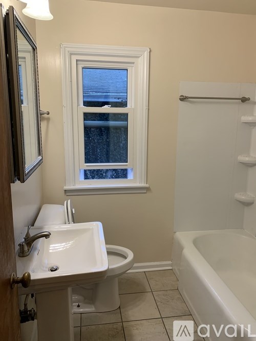 A bathroom with a white sink, toilet and bathtub.