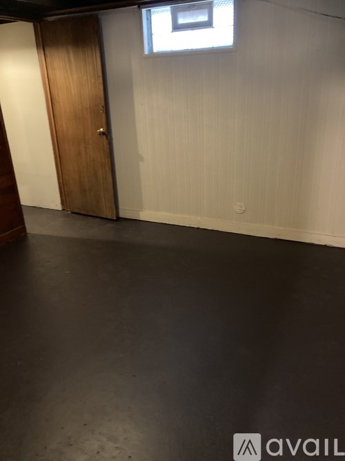 A room with a wooden door and a small window.