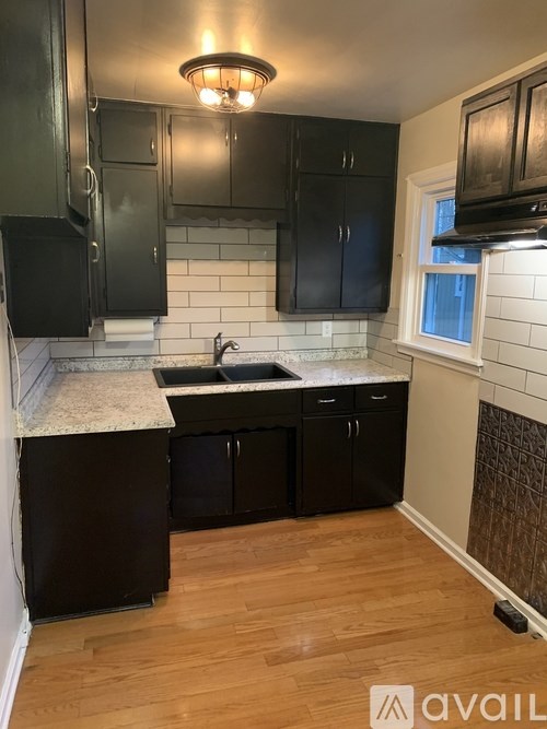 A kitchen with black cabinets and a white countertop.