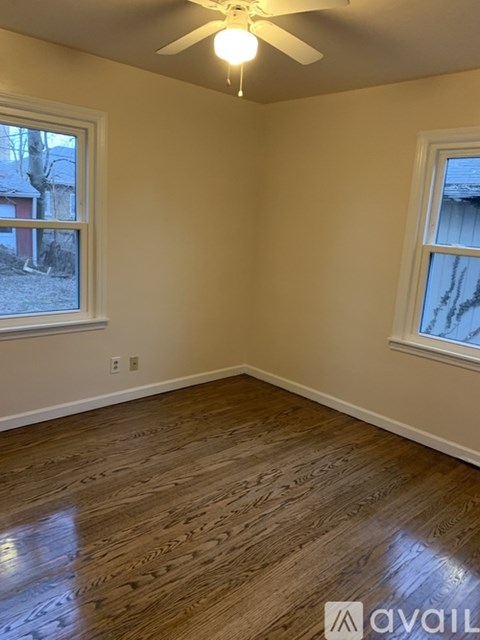 A room with wooden flooring and a ceiling fan.