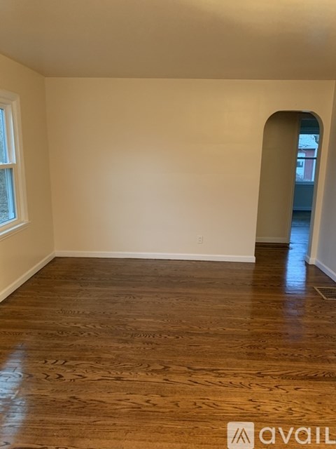 A room with wooden flooring and a window.