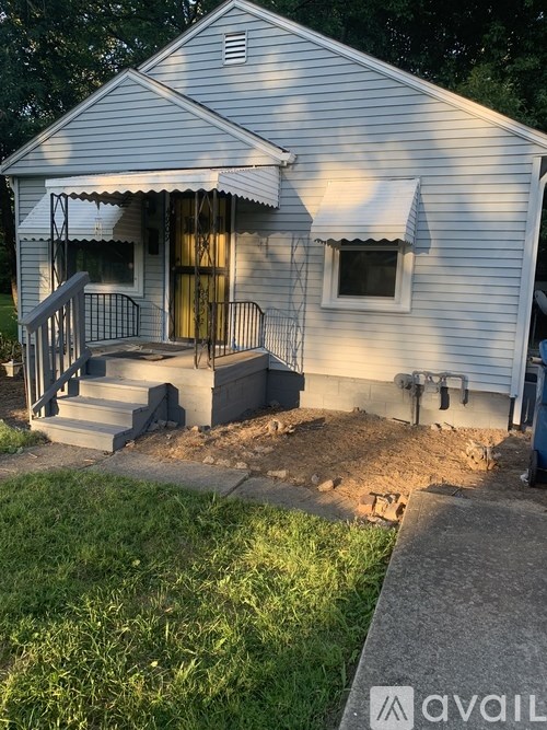 A small white house with a porch and a covered entrance.