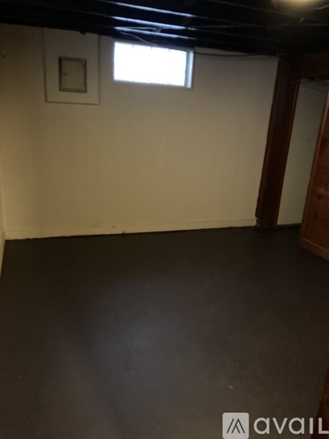 A room with a dark floor and a small window.