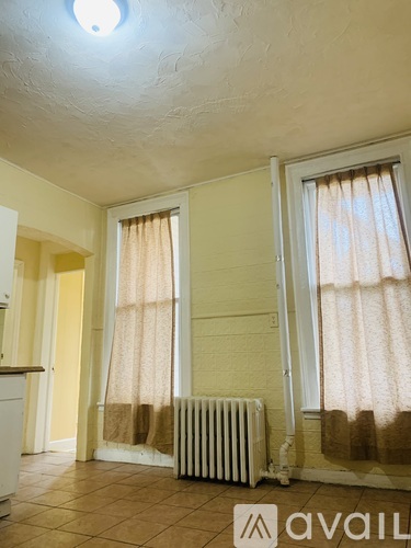 A hallway with a wooden floor and white walls.