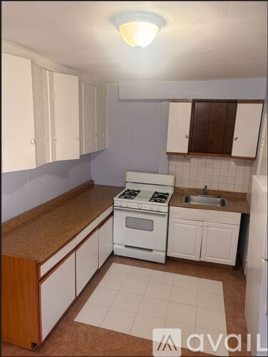 A kitchen with white appliances and brown countertops.
