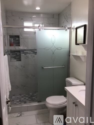 A bathroom with a toilet, sink and shower.