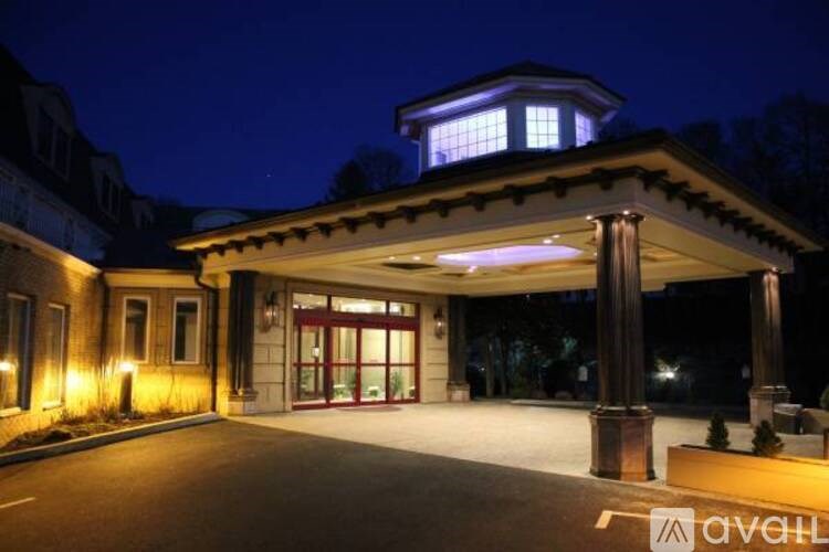 A building with a lit up entrance and pillars.