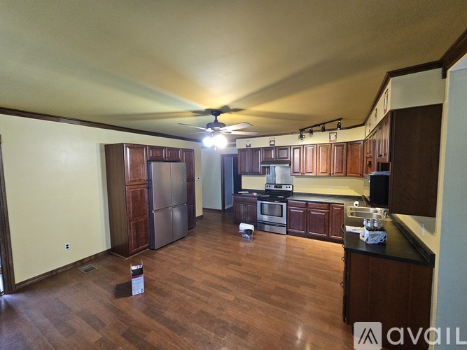 A kitchen with wooden floors and a ceiling fan.