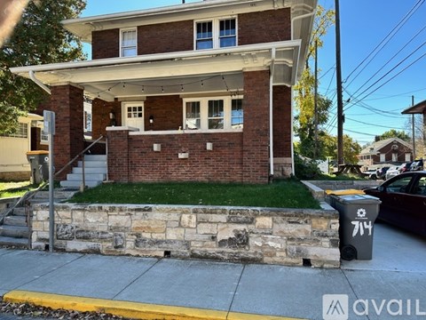 A two-story house with a brick facade and a stone foundation.