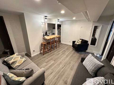 A living room with a grey couch and a wooden floor.