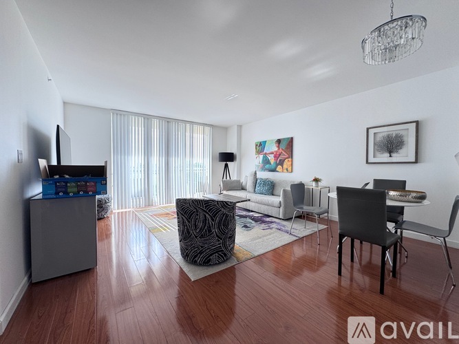 A bedroom with a large bed and a television on a dresser.