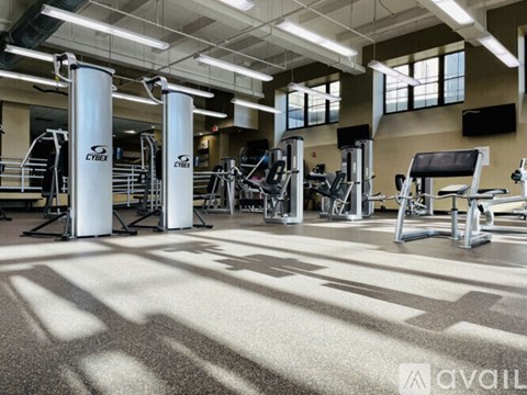 A gym with a variety of equipment including treadmills, weights, and exercise machines.