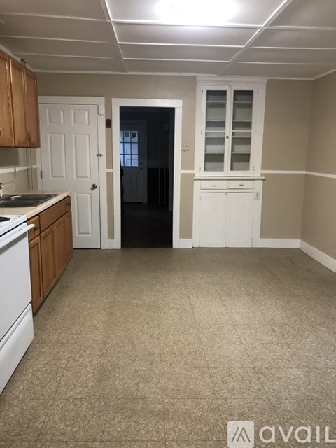A kitchen with white appliances and wooden cabinets.